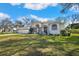 Attractive single-story home with a well-manicured lawn and mature shade trees at 13855 Rudi Loop, Spring Hill, FL 34609