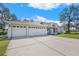 Expansive driveway leading to a three-car garage, set against a lush green lawn at 13855 Rudi Loop, Spring Hill, FL 34609