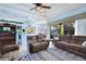 Inviting living room with tile floors, ceiling fan, and sliding glass doors to the outdoor screened living space at 13855 Rudi Loop, Spring Hill, FL 34609