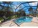 This enclosed pool offers a screened enclosure, brick trim, an in-pool ladder, and serene views at 13855 Rudi Loop, Spring Hill, FL 34609