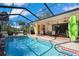 This enclosed pool boasts a screened enclosure, brick trim, an in-pool ladder and lovely patio seating at 13855 Rudi Loop, Spring Hill, FL 34609