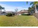 Spacious backyard featuring a screened patio, lush green lawn, and mature trees for shade at 14917 Barby Ave, Tampa, FL 33625