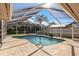 Screened in-ground pool with a clear blue sky at 14917 Barby Ave, Tampa, FL 33625