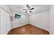 Bedroom with wood floors, ceiling fan, and a window with plantation shutters at 15901 Benton Ct, Tampa, FL 33647