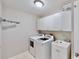 Well-equipped laundry room with modern washer, dryer, sink and white cabinetry at 15901 Benton Ct, Tampa, FL 33647