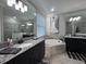 Bright bathroom featuring dual vanities, granite countertops, and a luxurious soaking tub at 17736 Hickok Belt Loop, Bradenton, FL 34211