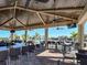 Outdoor community bar area under a covered pavilion with ceiling fans and mounted TV screens at 17736 Hickok Belt Loop, Bradenton, FL 34211