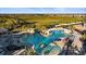 Resort-style community pool featuring rock waterfalls, sun loungers, and palm trees at 17736 Hickok Belt Loop, Bradenton, FL 34211