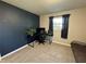 Bedroom with a large window, carpeting, and a dark blue accent wall with a black desk at 1919 E Noel St, Tampa, FL 33610