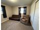 Cozy bedroom with carpet, recliner, and futon, enhanced by natural light from the windows with black curtains at 1919 E Noel St, Tampa, FL 33610