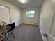 Carpeted bedroom featuring a natural light from the window and is furnished with a unique woven chair at 1919 E Noel St, Tampa, FL 33610