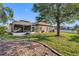 Spacious backyard featuring a screened-in lanai, well-manicured lawn, and mature landscaping at 2037 Blue River Rd, Holiday, FL 34691