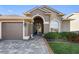 Welcoming front entrance with an arched doorway and a paved walkway leading to the front door at 2037 Blue River Rd, Holiday, FL 34691