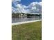 Scenic waterfront view of a calm waterway and beautiful homes on a sunny day with a lush green lawn in the foreground at 2102 W Ivy St, Tampa, FL 33607