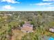 Aerial view of the house with a brown roof surrounded by mature trees in a verdant neighborhood at 2151 E Leewynn Dr, Sarasota, FL 34240