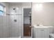 Bathroom with a tiled walk-in shower, single vanity sink, and an open doorway at 2151 E Leewynn Dr, Sarasota, FL 34240