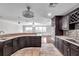 Modern kitchen with dark cabinets, granite countertops and a view into the dining and living area at 2151 E Leewynn Dr, Sarasota, FL 34240