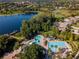 Aerial view of the community pool area, the lake, and the surrounding homes and natural landscape at 21537 Draycott Way, Land O Lakes, FL 34637