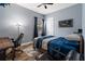 Comfortable bedroom with blue walls, ceiling fan, wood floors, desk, and a cozy bed for a relaxing and functional space at 21537 Draycott Way, Land O Lakes, FL 34637