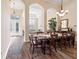 Elegant dining room featuring a large table set for dinner, high ceilings, and arched doorways at 21537 Draycott Way, Land O Lakes, FL 34637