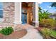 Inviting front entryway with a blue glass door, brick pathway, and lush landscaping at 21537 Draycott Way, Land O Lakes, FL 34637