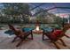 Tranquil pool and fire pit with cozy chairs in the backyard at 21537 Draycott Way, Land O Lakes, FL 34637