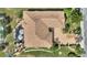 Birds eye view of the property with a screened lanai, mature landscaping and a brick driveway at 2359 Emerald Lake Dr, Sun City Center, FL 33573