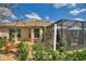 Exterior view of home with a screened patio, gravel, garden beds, and landscape at 2359 Emerald Lake Dr, Sun City Center, FL 33573