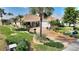 An elevated view of the house showcasing lush landscaping and brick driveway at 2359 Emerald Lake Dr, Sun City Center, FL 33573