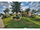 Beautifully landscaped yard featuring mature trees and lush green grass at 2359 Emerald Lake Dr, Sun City Center, FL 33573