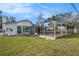 Back view of house featuring a pool with a screen enclosure and a backyard with grass at 239 Freeport Ne Ave, St Petersburg, FL 33702