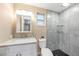 Modern bathroom featuring a new vanity, tiled shower with glass shelves, and dark stone flooring at 239 Freeport Ne Ave, St Petersburg, FL 33702