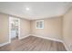 Empty bedroom with wood-look floors, a window, neutral walls and a view of an ensuite bath at 239 Freeport Ne Ave, St Petersburg, FL 33702