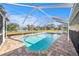 Backyard view of a pool with clear water inside a screened enclosure and patio at 239 Freeport Ne Ave, St Petersburg, FL 33702