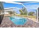 Inviting pool with clear blue water surrounded by brick pavers and a screened enclosure at 239 Freeport Ne Ave, St Petersburg, FL 33702