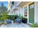 Charming outdoor seating area featuring stylish chairs, potted plants, and a beautiful green front door at 2510 W Cleveland St # 3, Tampa, FL 33609