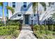 The townhome is surrounded by lush greenery, a black metal fence, and a stone walkway leading to the entrance at 2510 W Cleveland St # 3, Tampa, FL 33609