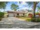 Inviting one-story home with manicured landscaping, lush garden beds, and a lengthy driveway approach at 2940 Bay View Dr, Safety Harbor, FL 34695