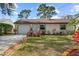 Charming single-story home with a well-manicured lawn, brick-lined walkway, and attached garage at 2940 Bay View Dr, Safety Harbor, FL 34695