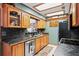 Functional kitchen with wooden cabinetry, black countertops, stainless steel appliances, and bright lighting at 2940 Bay View Dr, Safety Harbor, FL 34695