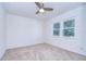 Bright bedroom featuring plush carpeting, a modern ceiling fan, and large windows offering natural light at 3046 Lake Padgett Dr, Land O Lakes, FL 34639