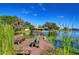 Scenic view of a lake with a private dock and seating, surrounded by lush greenery and blue skies at 3046 Lake Padgett Dr, Land O Lakes, FL 34639