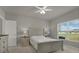 Bright bedroom with neutral tones, featuring a queen bed, side tables, and large window for natural light at 3664 Zephyr Preserve Pl, Zephyrhills, FL 33541