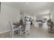 Open floor plan with tile flooring, with dining room table and kitchen with bar seating in background at 3664 Zephyr Preserve Pl, Zephyrhills, FL 33541