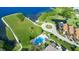 Aerial view of community featuring a pool, lake, and lush green space at 423 Windrush Bay Dr, Tarpon Springs, FL 34689