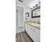 Bathroom with modern vanity, stylish mirror, and wood-look vinyl flooring at 423 Windrush Bay Dr, Tarpon Springs, FL 34689