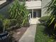 Landscaped walkway leading to a quaint condo entrance with a white gate at 423 Windrush Bay Dr, Tarpon Springs, FL 34689