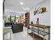 Stylish living room with tile flooring, a modern black leather sofa, and a wooden shelving unit at 423 Windrush Bay Dr, Tarpon Springs, FL 34689