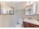 Powder room with a cherry wood vanity, mirror, and tile flooring at 4606 W Oakellar Ave, Tampa, FL 33611