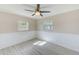 Bright bedroom featuring wood-look flooring, wainscoting, ceiling fan, and natural light from two windows at 4606 W Oakellar Ave, Tampa, FL 33611